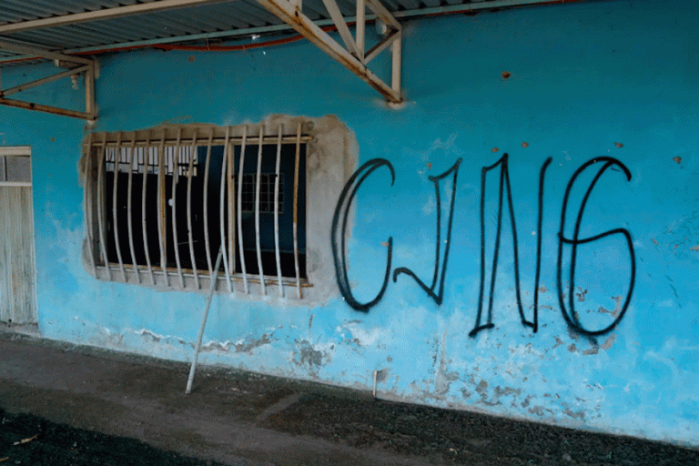 ARCHIVO – Las siglas del Cártel Jalisco Nueva Generación cubren la fachada de una vivienda abandonada en El Limoncito, en el estado mexicano de Michoacán, el 30 de octubre de 2021. (AP Foto/Eduardo Verdugo, Archivo)