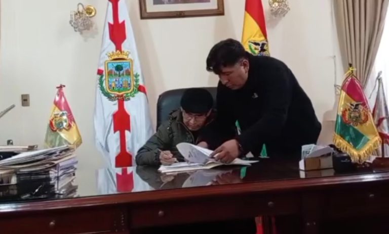 Damián Condori firmando documentos en su despacho